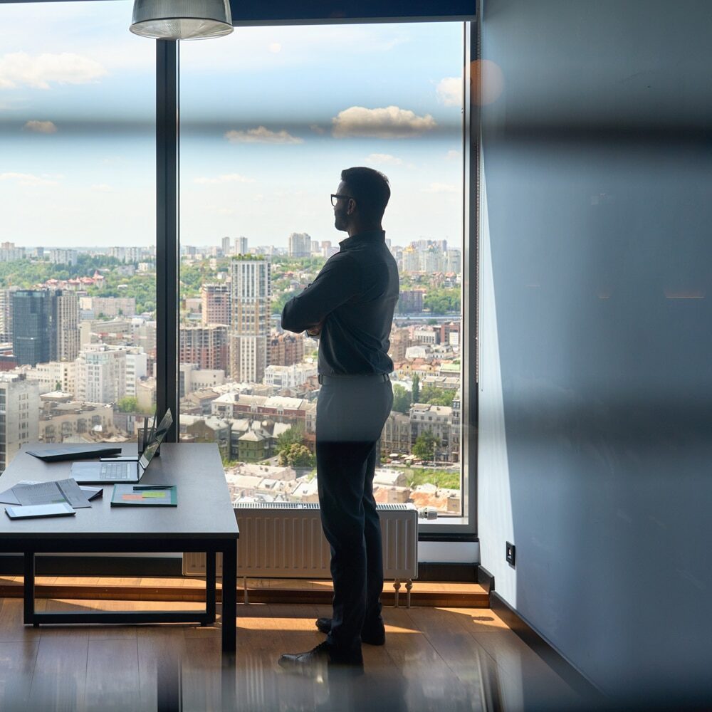 Person looking out high-rise office window